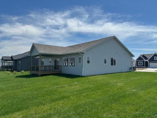 rear view of property featuring a yard and a wooden deck