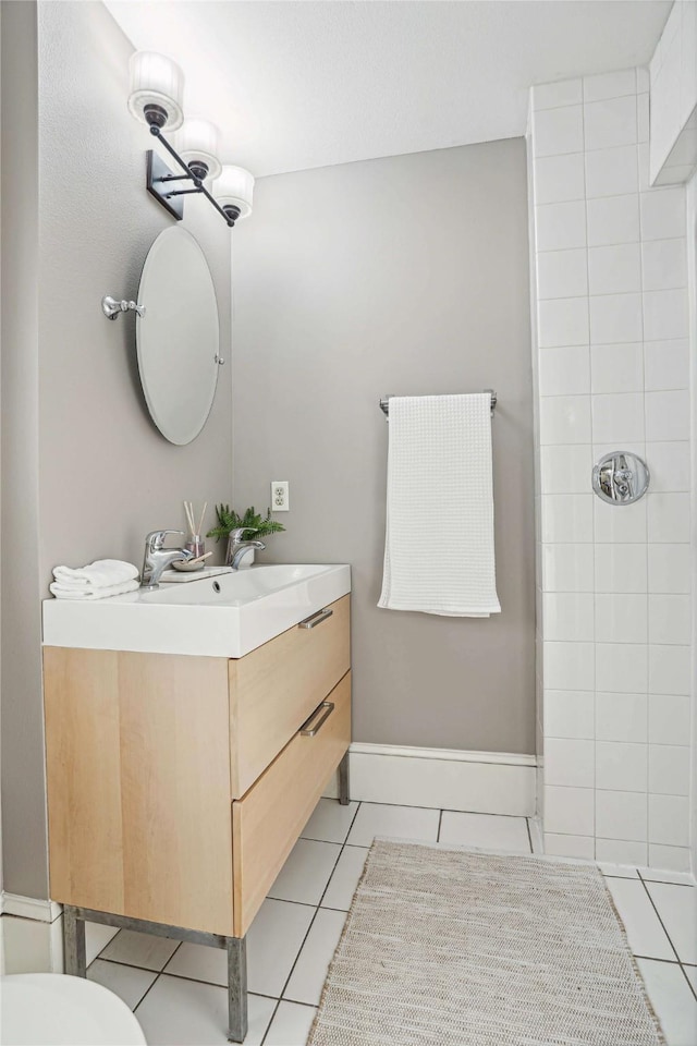 bathroom featuring tile patterned flooring, vanity, toilet, and walk in shower