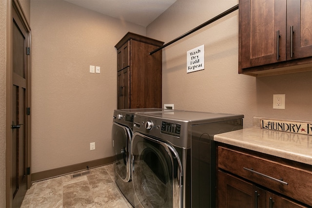 laundry room featuring cabinets and washing machine and dryer