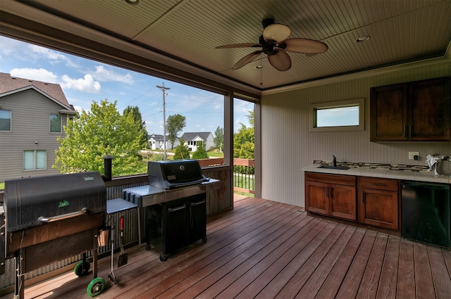 wooden terrace featuring grilling area, an outdoor kitchen, sink, and ceiling fan