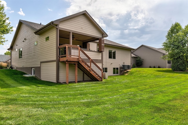 rear view of property with ceiling fan, a yard, a wooden deck, and central AC unit