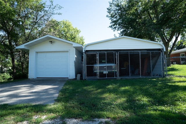 view of front of home featuring an outbuilding, a garage, and a front lawn