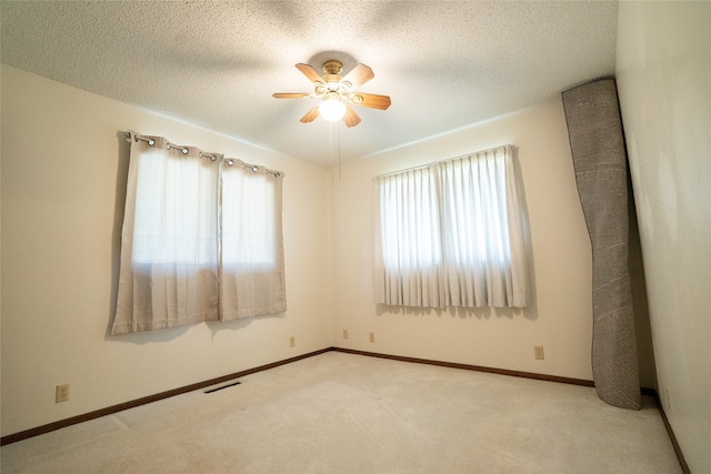 carpeted empty room with a textured ceiling and ceiling fan