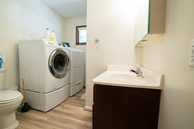 laundry area featuring light hardwood / wood-style floors, independent washer and dryer, and sink