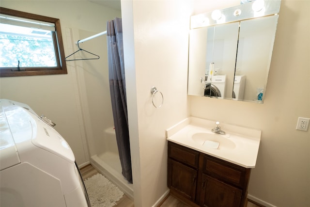 bathroom featuring a shower with shower curtain, independent washer and dryer, and vanity