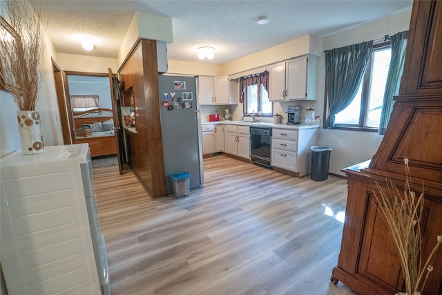 kitchen with stainless steel fridge, black dishwasher, white cabinetry, and a textured ceiling