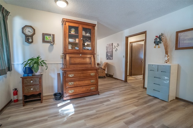 misc room with light wood-type flooring and a textured ceiling