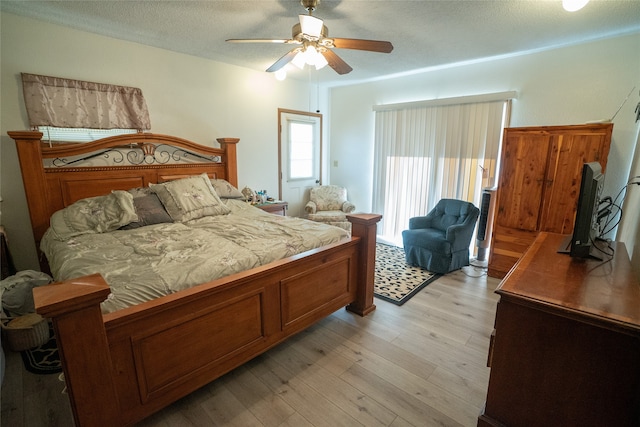 bedroom featuring a textured ceiling, light hardwood / wood-style flooring, and ceiling fan