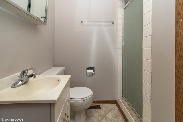 bathroom featuring vanity, toilet, an enclosed shower, and tile patterned floors