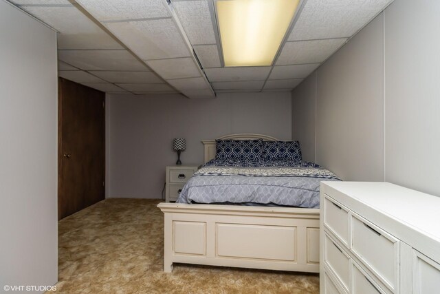 carpeted bedroom featuring a drop ceiling