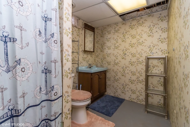 bathroom featuring a paneled ceiling, a shower with curtain, toilet, and vanity