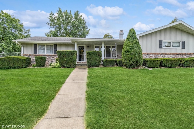 ranch-style house with brick siding, a chimney, and a front lawn