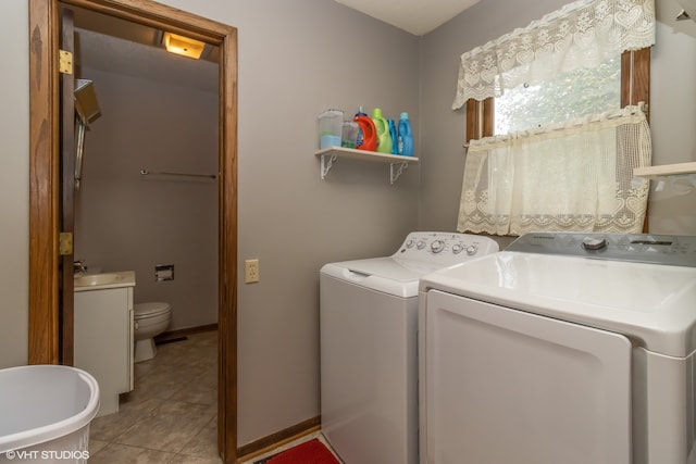 clothes washing area with independent washer and dryer and light tile patterned floors