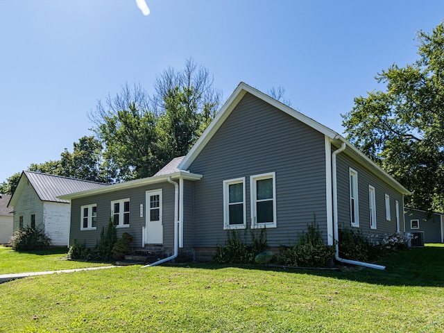 view of front facade with a front yard and central AC