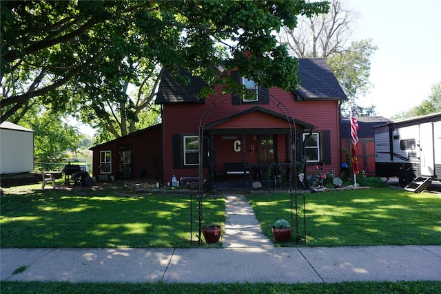 view of front of property with a front lawn, covered porch, and a shingled roof