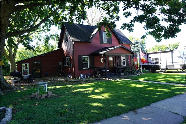 view of front of house featuring a front lawn and a shingled roof