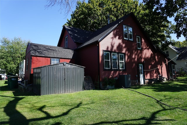 view of property exterior with an outbuilding, a lawn, cooling unit, and a storage unit