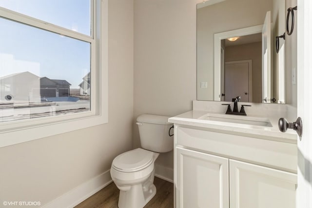 bathroom with toilet, vanity, and hardwood / wood-style floors