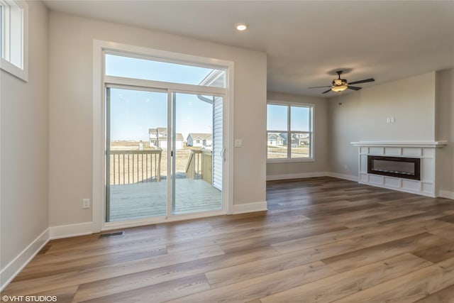 unfurnished living room with ceiling fan and hardwood / wood-style floors