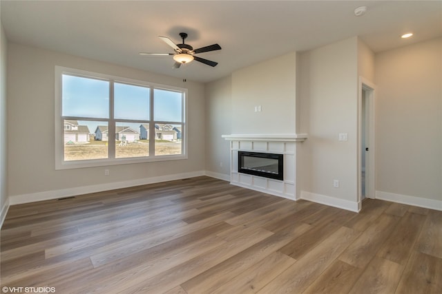 unfurnished living room featuring ceiling fan and hardwood / wood-style flooring