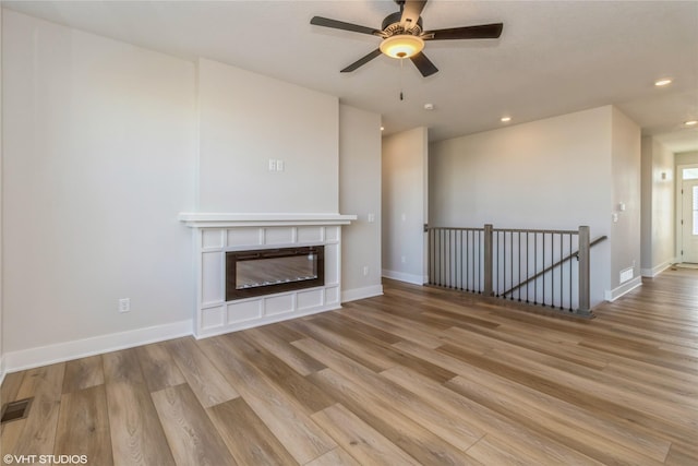 unfurnished living room featuring light wood-type flooring and ceiling fan