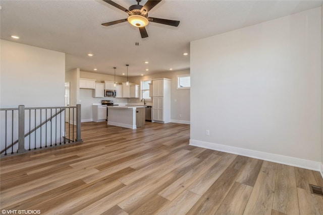 unfurnished living room with ceiling fan and light hardwood / wood-style floors