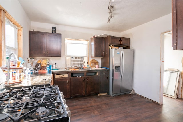 kitchen with dark wood-type flooring, track lighting, sink, dark brown cabinets, and stainless steel appliances