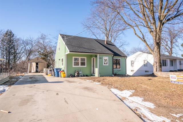 bungalow-style home with a storage unit