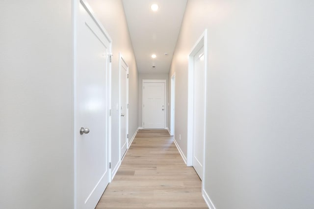 hallway with recessed lighting, light wood-style flooring, and baseboards