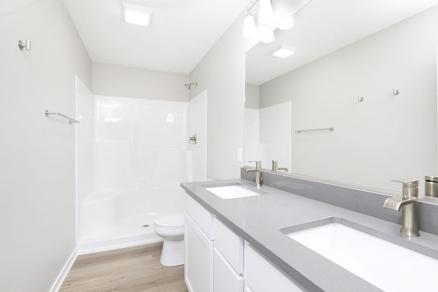 full bathroom with a shower, a sink, toilet, and wood finished floors