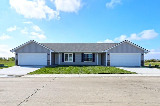 single story home with a garage, stone siding, a front lawn, and concrete driveway