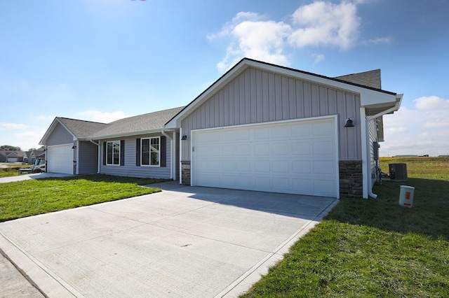 single story home with central AC unit, board and batten siding, a front yard, a garage, and stone siding