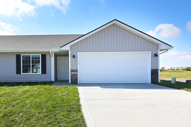 single story home with a garage, stone siding, concrete driveway, and a front yard