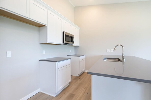 kitchen featuring light hardwood / wood-style flooring, sink, and white cabinets