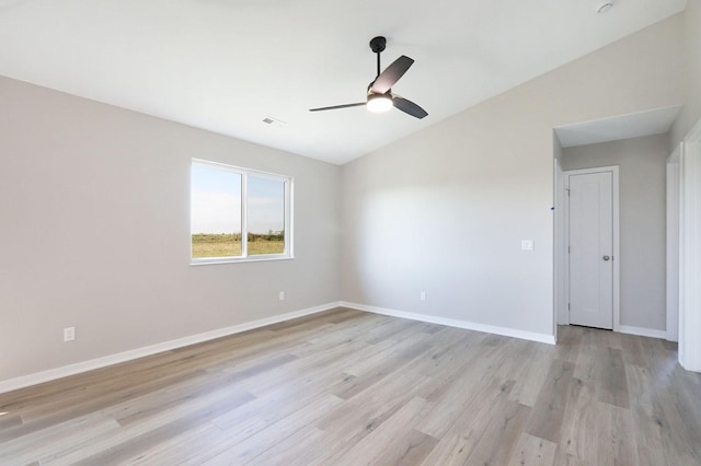 spare room with lofted ceiling, ceiling fan, baseboards, and light wood-style floors