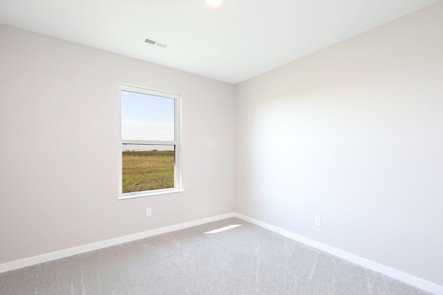 carpeted spare room featuring visible vents and baseboards