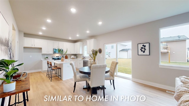 dining space featuring light wood-type flooring and sink