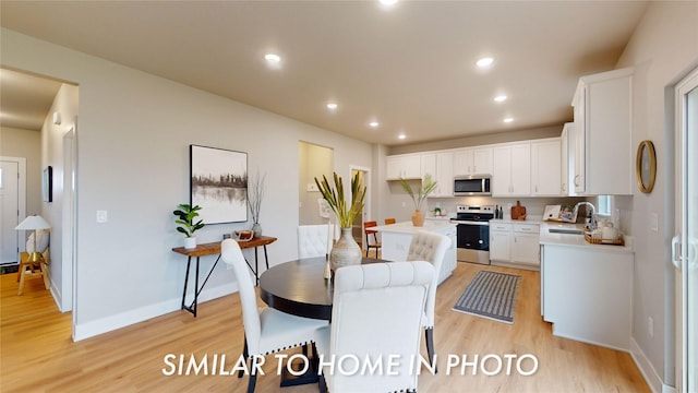 dining area featuring sink and light hardwood / wood-style flooring