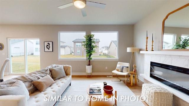 living room with ceiling fan, light hardwood / wood-style floors, and a fireplace