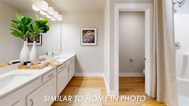 bathroom with hardwood / wood-style floors, vanity, and toilet