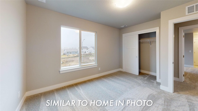 unfurnished bedroom with light colored carpet and a closet