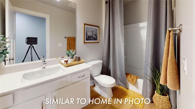 full bathroom with vanity, shower / tub combo, and toilet