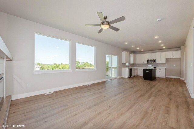 2231 Chan Dr, Adel, IA 50003 - unfurnished living room with recessed lighting, light wood-type flooring, a ceiling fan, and a fireplace