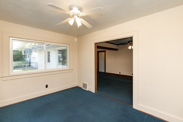 carpeted empty room featuring ceiling fan