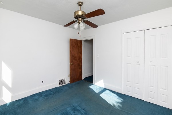 unfurnished bedroom with a closet, ceiling fan, and carpet