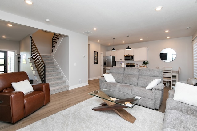 living room with light hardwood / wood-style floors and sink