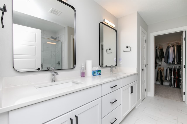 bathroom featuring a shower with shower door and vanity