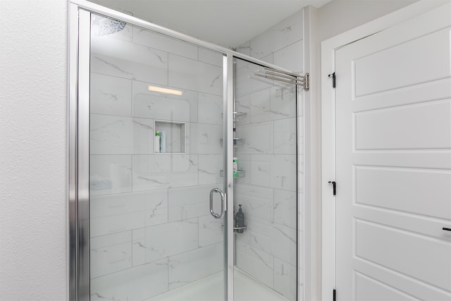 bathroom featuring a shower with door