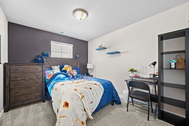 carpeted bedroom featuring visible vents, a textured ceiling, and baseboards