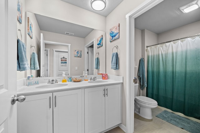 full bath with double vanity, toilet, visible vents, and a sink